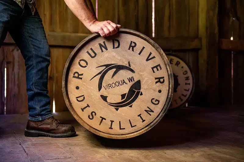 Hands holding a barrel of Round River Whiskey